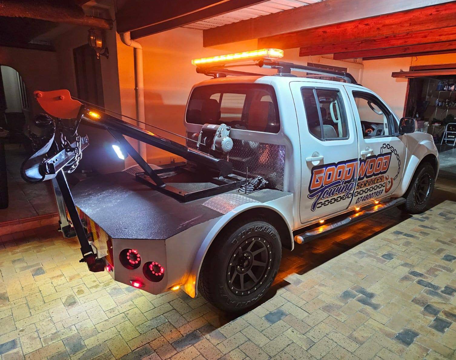 Goodwood Towing Services recovery vehicle lit up at night